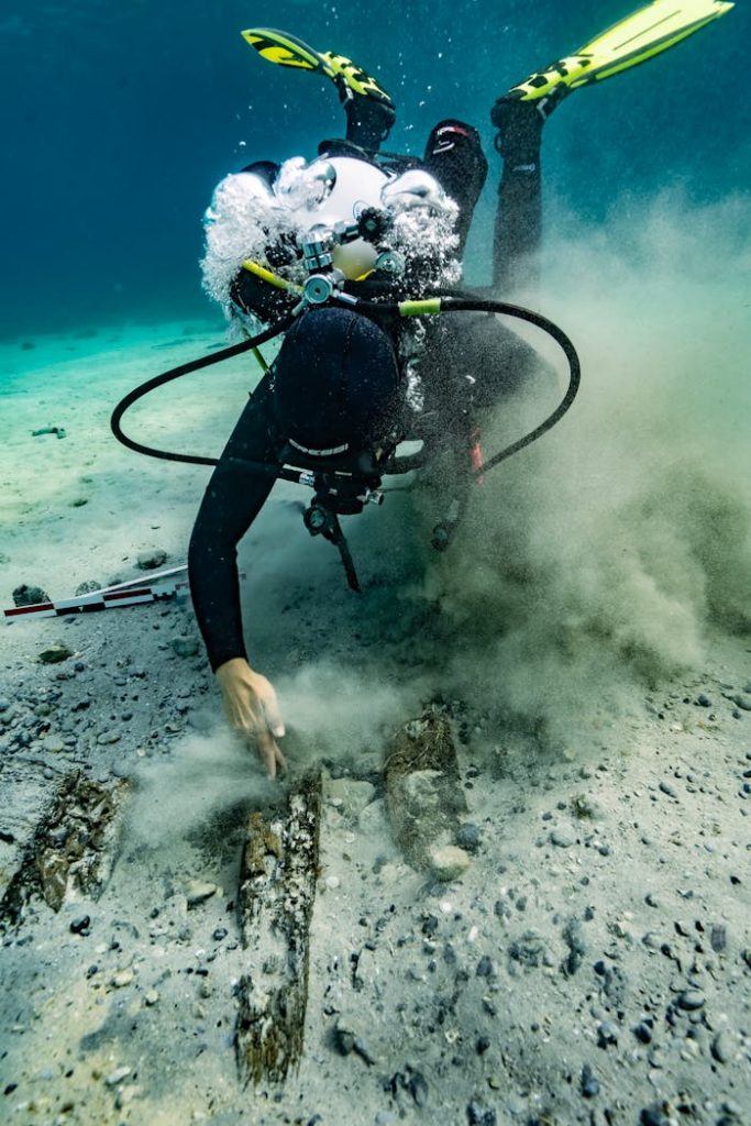 pexels photo 19942717 A scuba diver inspects the seabed underwater in Croatia, surrounded by bubbles and sand.